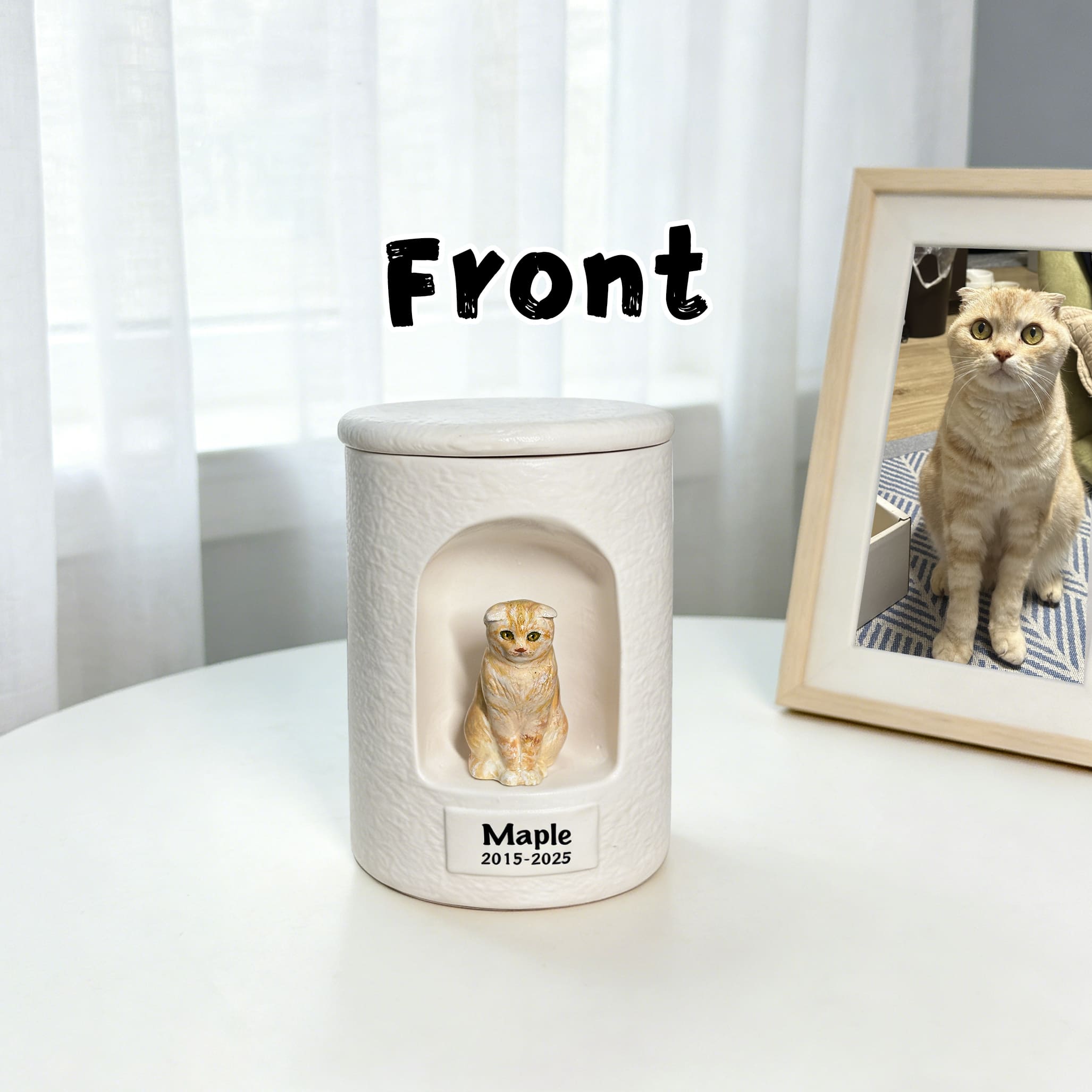 White ceramic cat memorial urn with sculpted light tabby figurine on front panel