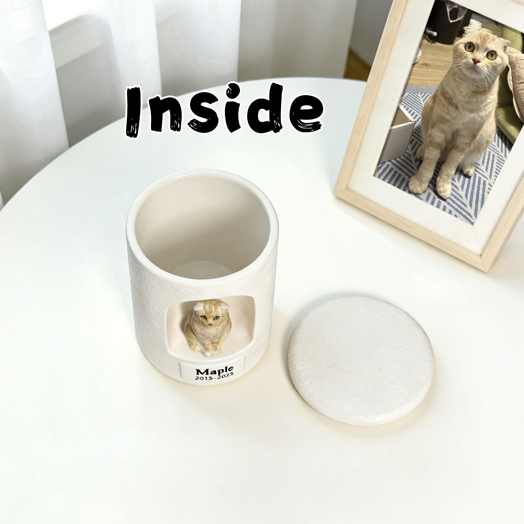 White ceramic cat urn with sculpted figurine inside and round sealed lid shown