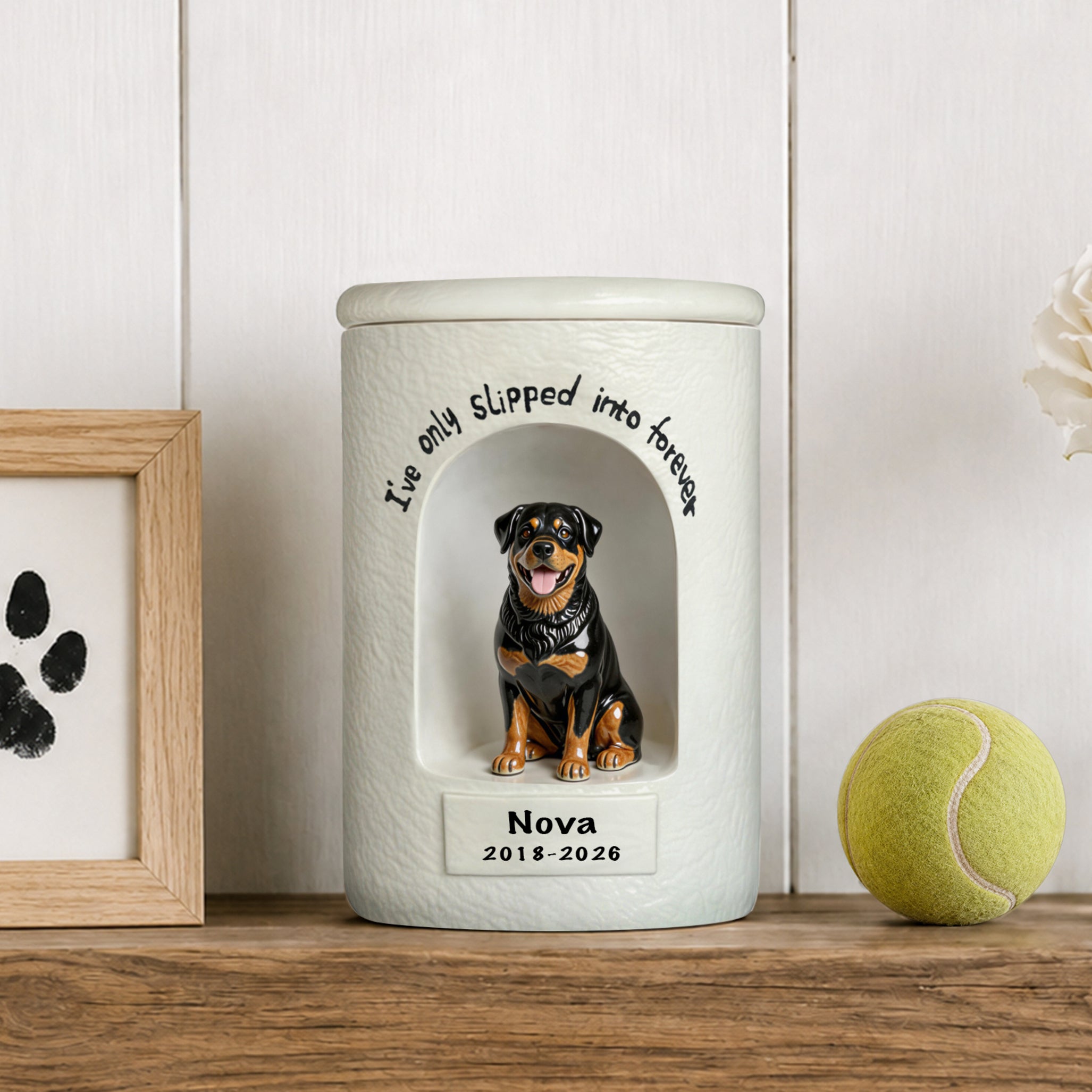 White ceramic dog memorial urn with seated rottweiler portrait on front and engraved name/date