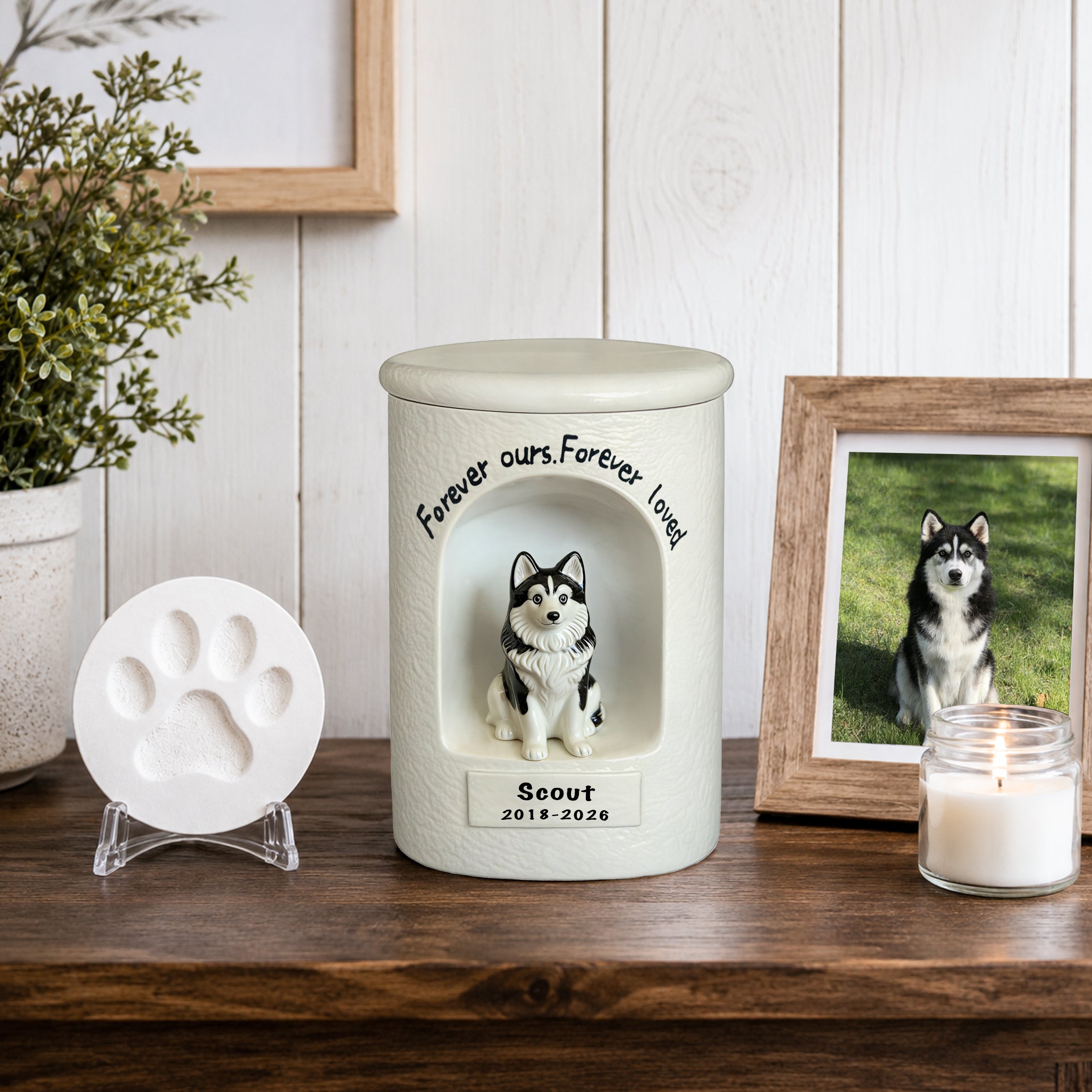 White ceramic dog memorial urn with seated dog figurine portrait, plus paw-print base plate