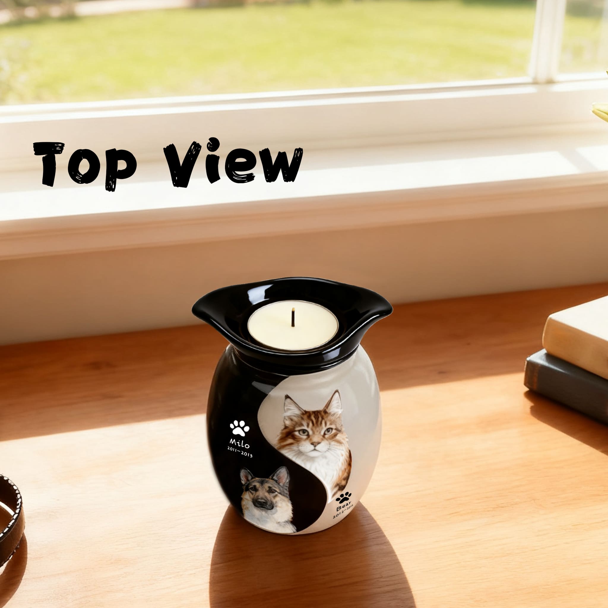 Double pet urn in view with black lid and lit candle, showing two pet portraits on front.