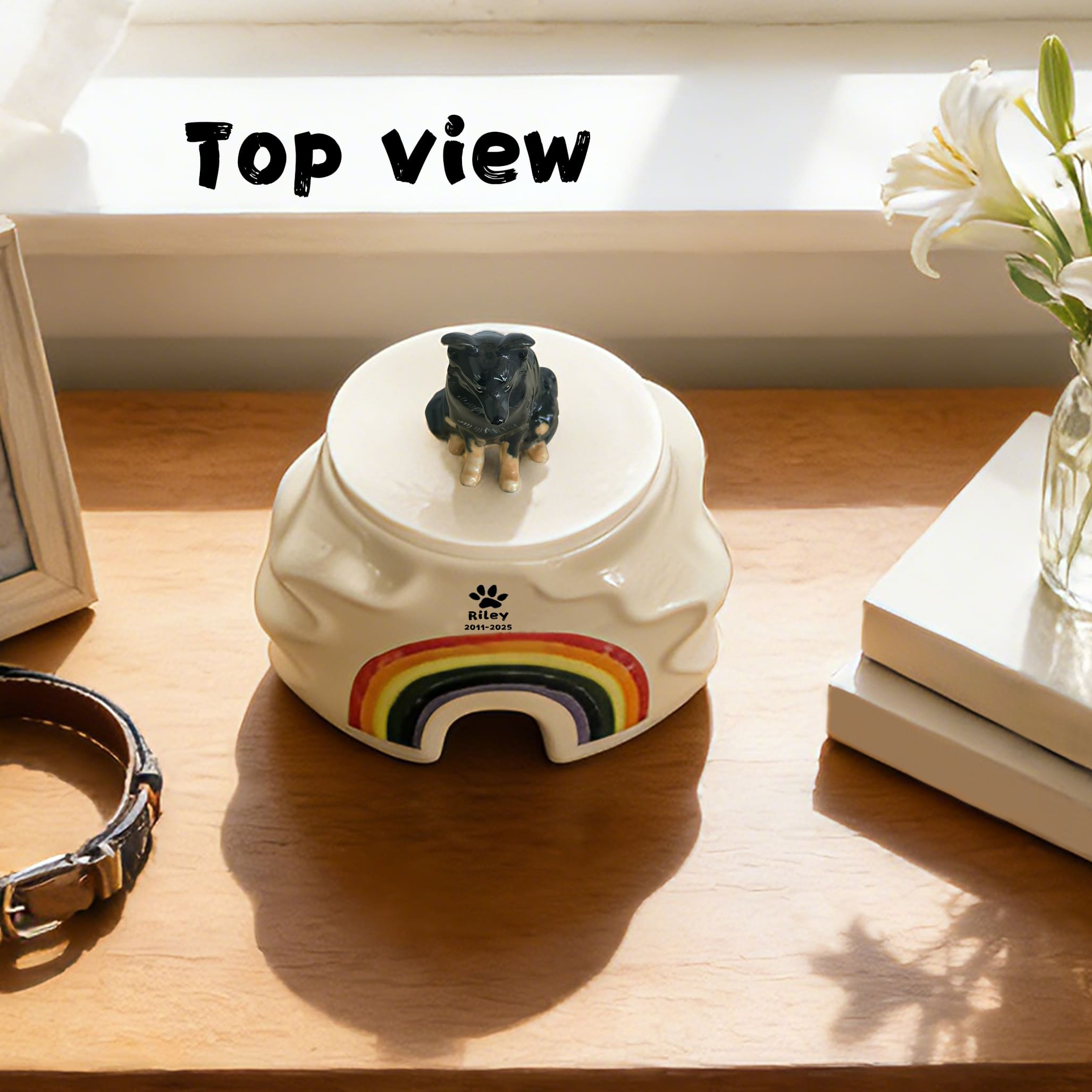 Cream ceramic pet urn top view with black dog figurine on lid and rainbow front