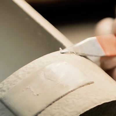 Artist sculpting and hand painting a personalized ceramic dog urn
