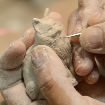 Personalized ceramic cat urn making process with handcrafted figurine and hand-painted memorial details.